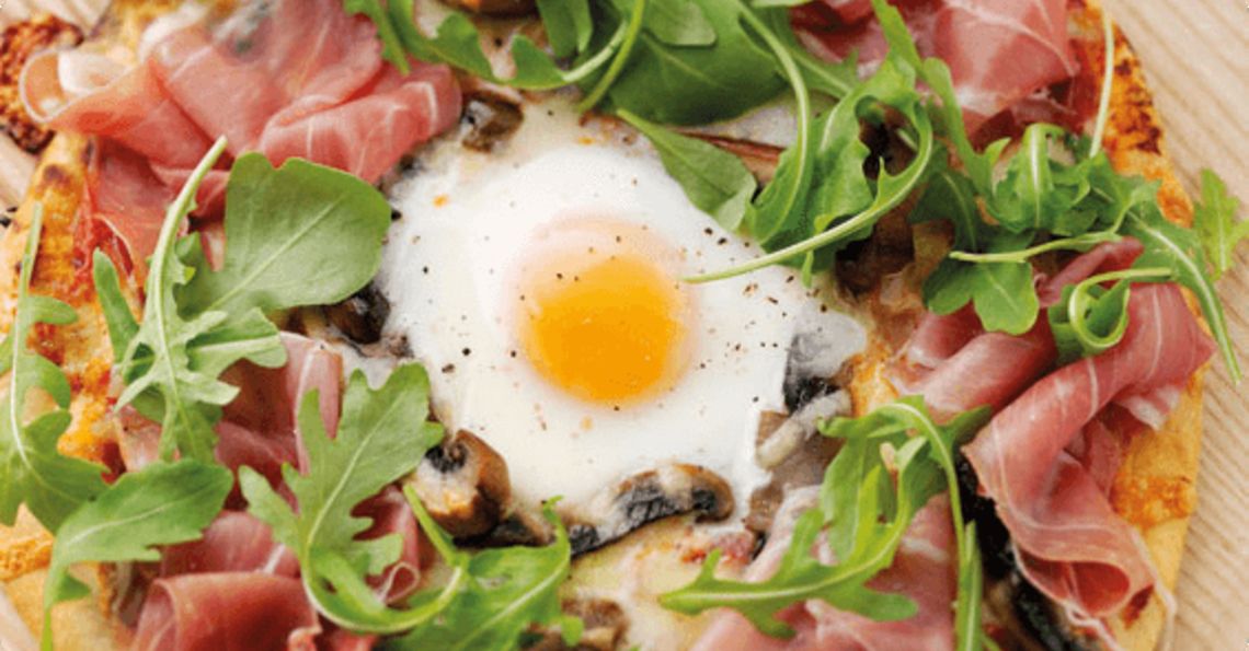 Baked egg pizza with portabella mushroom and cured ham