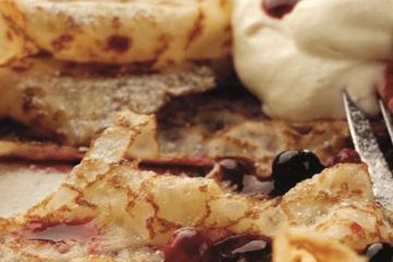 Lacy pancakes served with rosewater berries